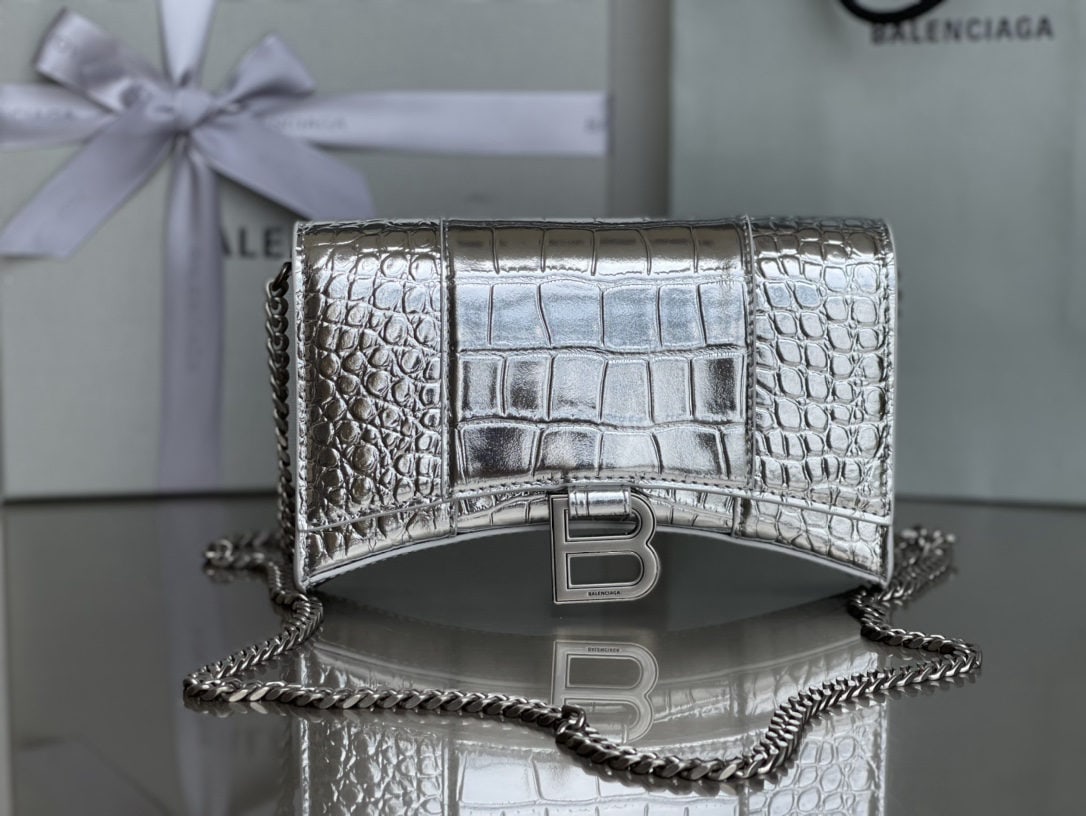 Balenciaga: We offer FREE SHIPPING for both domestic and international clients who bid over $500. The Balenciaga hourglass bag with crocodile silver clasp and chain strap features a unique and iconic curved