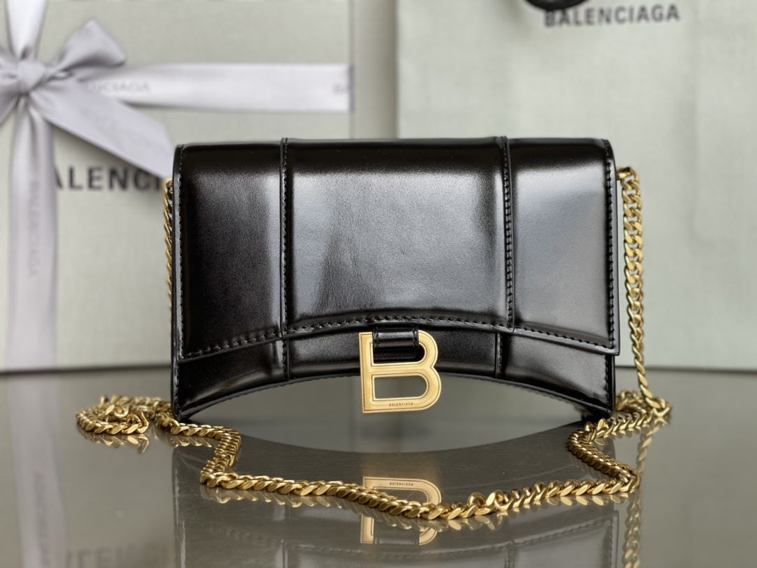 Balenciaga: We offer FREE SHIPPING for both domestic and international clients who bid over $500. The Balenciaga hourglass bag with a chain and gold hardware features a distinctive, iconic curved shape that is in