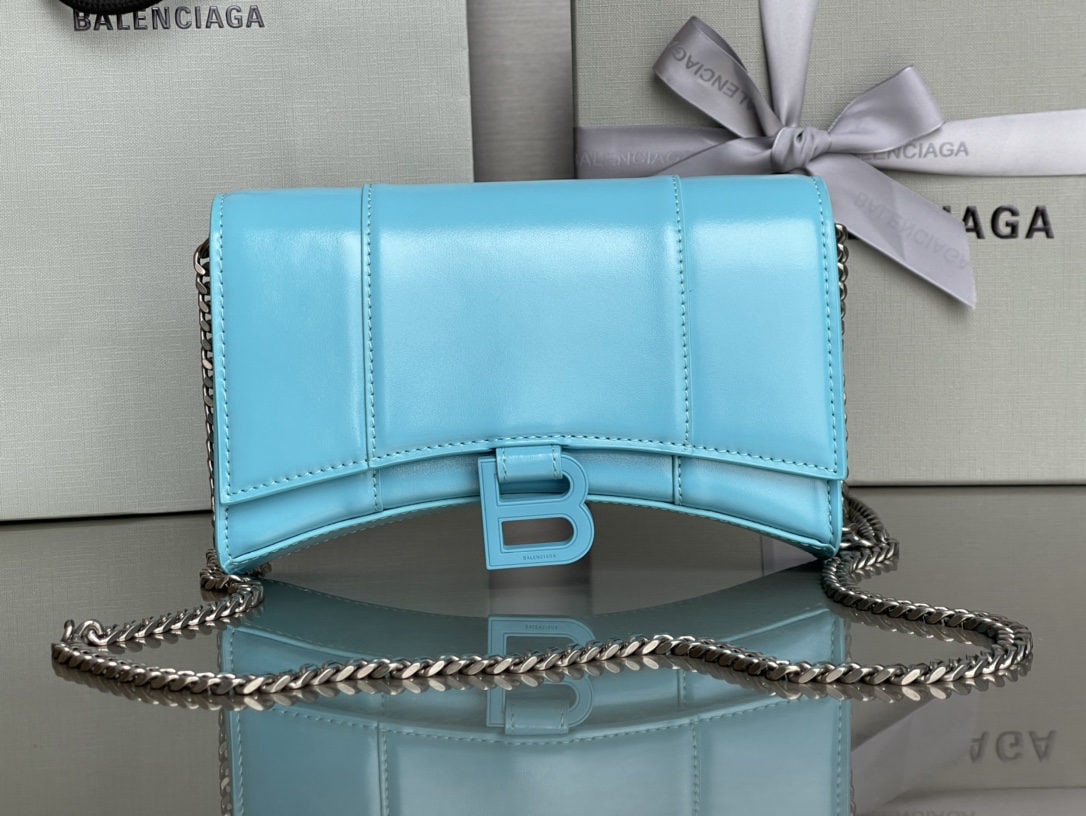 Balenciaga: We offer FREE SHIPPING for both domestic and international clients who bid over $500. This Balenciaga hourglass bag with a blue buckle and a plain, light blue finish features a distinctive, iconic cur