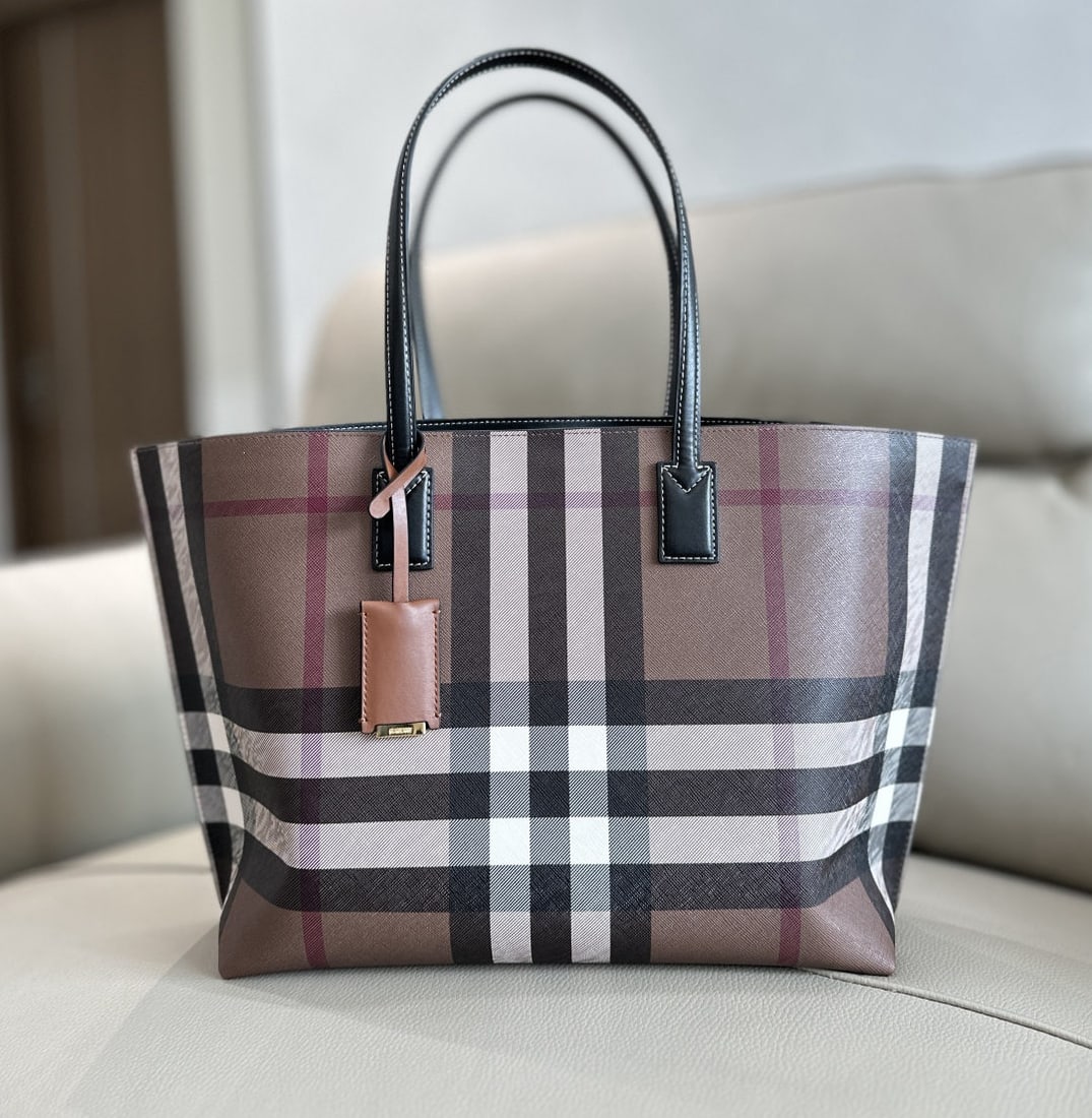 Burberry: We offer FREE SHIPPING for both domestic and international clients who bid over $500. Burberry's signature birchwood check tote bag features the iconic check pattern, topstitched leather trim, and a l