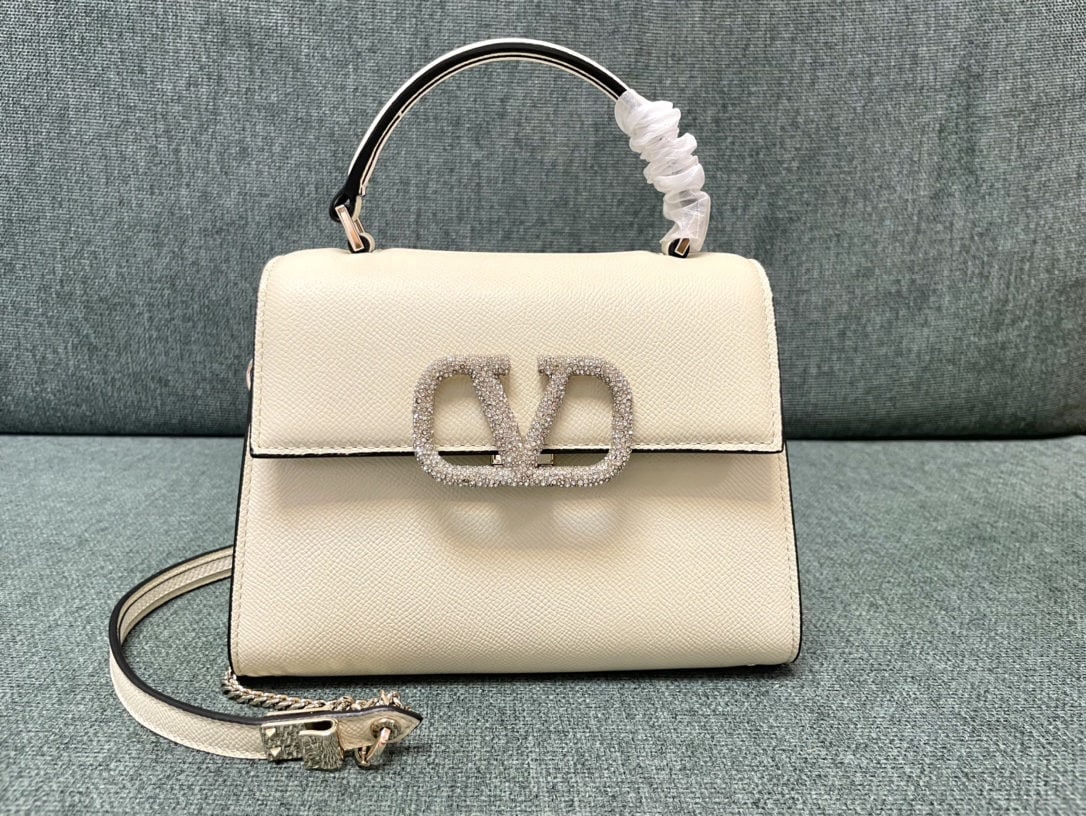 Valentino Garavani VSLING: We offer FREE SHIPPING for both domestic and international clients who bid over $500. The off-white mini Valentino Garavani VSLING Valentino with diamond buckle features an extendable two-tone shoulde