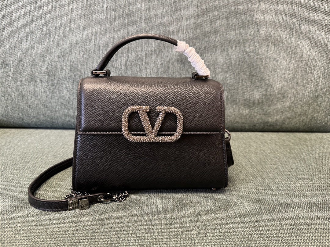 Valentino Garavani VSLING: We offer FREE SHIPPING for both domestic and international clients who bid over $500. The black Valentino Garavani VSLING mini bag with diamond buckle features an extendable two-tone shoulder strap an