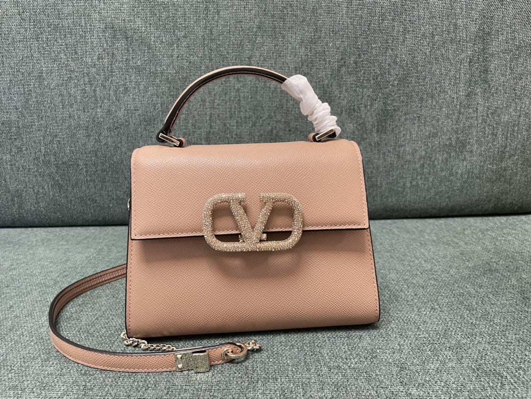Valentino Garavani VSLING: We offer FREE SHIPPING for both domestic and international clients who bid over $500. The mini Valentino Garavani VSLING Valentino bag with nude pink diamond buckle features an extendable two-tone sho