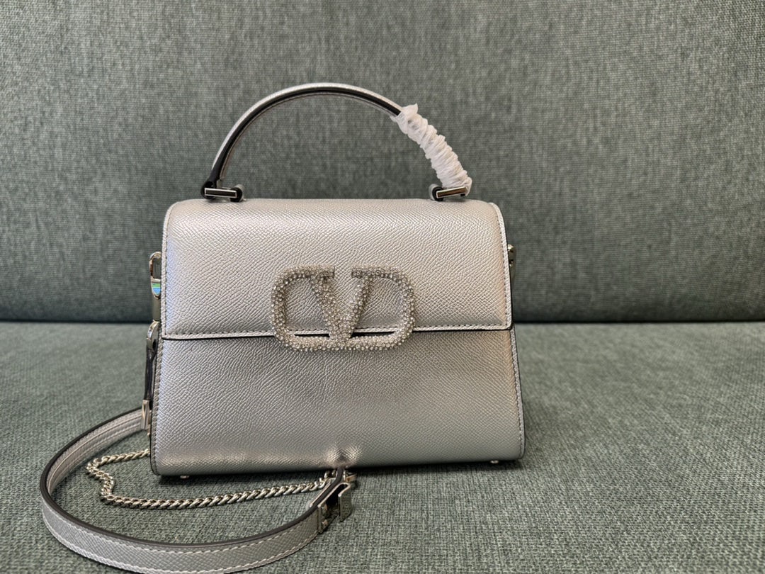 Valentino Garavani VSLING: We offer FREE SHIPPING for both domestic and international clients who bid over $500. The silver-plated, rhinestone-buckled mini Valentino Garavani VSLING features an extendable two-tone shoulder stra