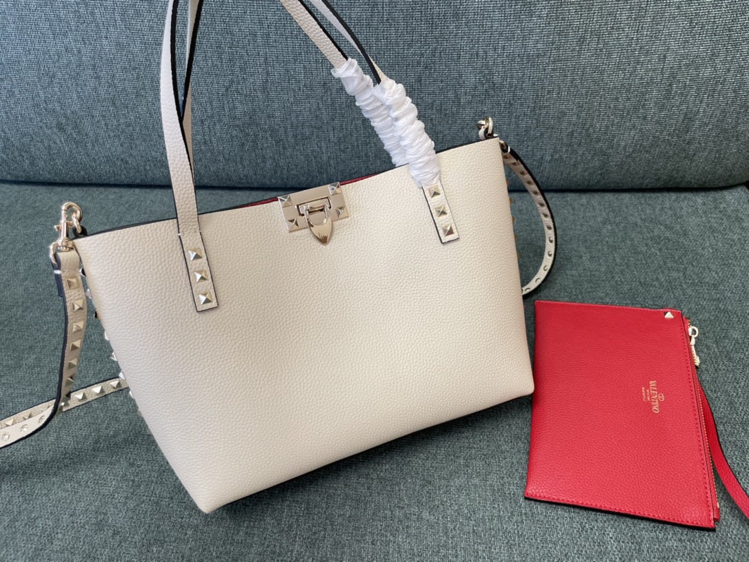Valentino: We offer FREE SHIPPING for both domestic and international clients who bid over $500. Off-white and red Valentino reversible shopping bag, pebbled leather with a detachable zippered pouch. Size: 26cm.