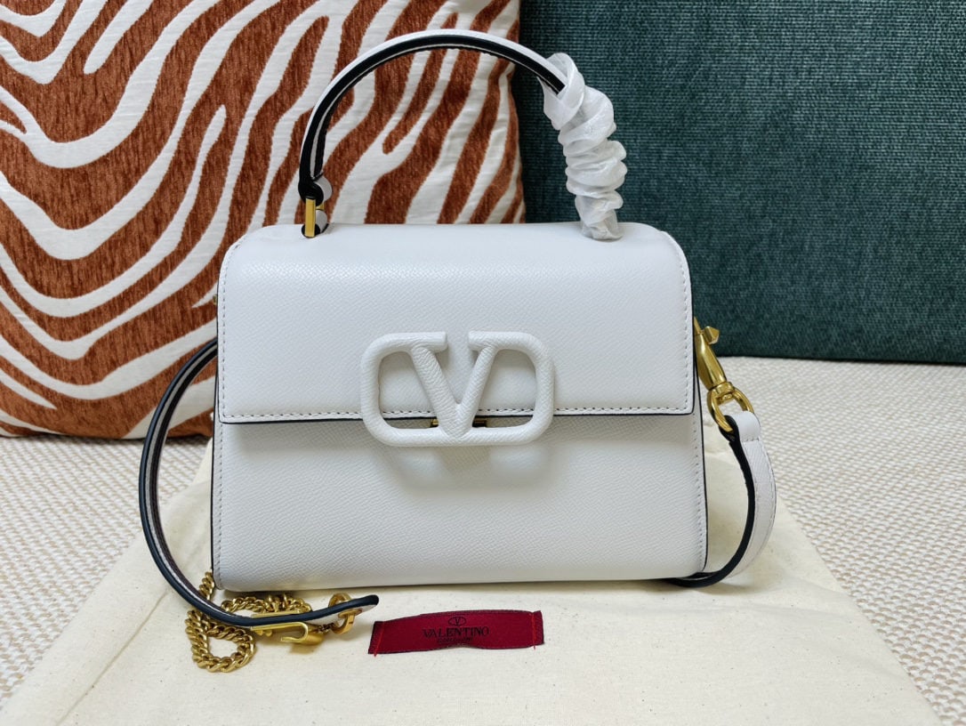Valentino Garavani VSLING: We offer FREE SHIPPING for both domestic and international clients who bid over $500. This white mini Valentino Garavani VSLING briefcase features a palm print design and comes with an extendable two-