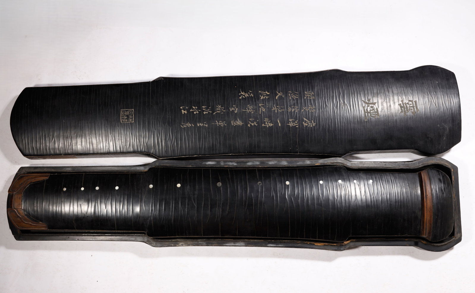 Qing Dynasty Remarkable LACQUERED WOOD GUQIN with case: A Remarkable LACQUERED WOOD GUQIN WITH INSCRIBED CALLIGRAPHY (Lacquered wood with engraved inscriptions and fitted case)Qing Dynasty, 18th CenturyLength 120cm. Width 20.5cm. Description: This elegant 