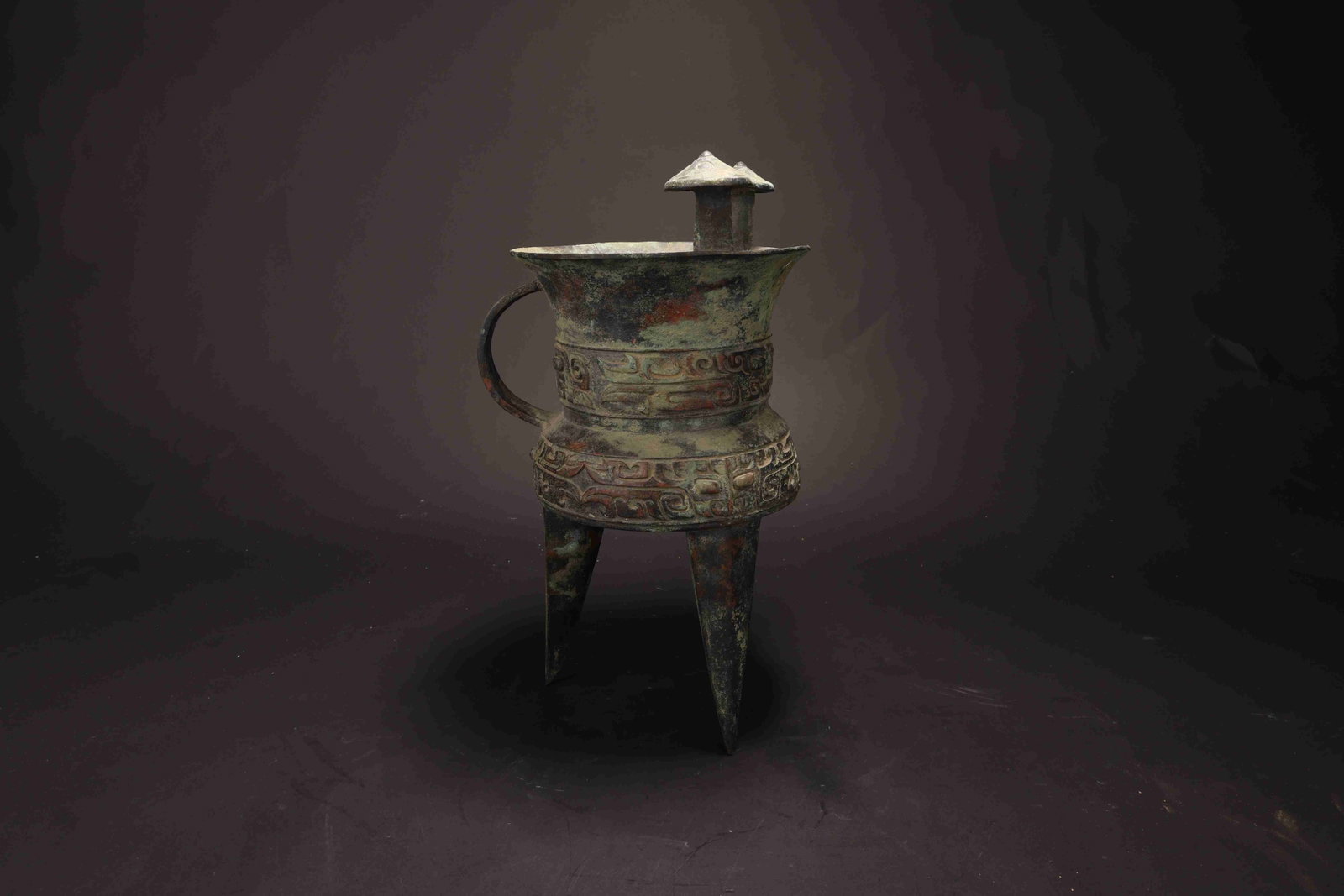 Shang Dynasty Bronze Jue (Ritual Wine Vessel): Shang Dynasty Bronze Jue (Ritual Wine Vessel)Shang Dynasty, c. 16th-11th Century BC Height: 28.5cm Mouth Diameter: 14.5cm Weight: 2032g. Description: An archaic bronze tripod wine vessel, jue, the dee