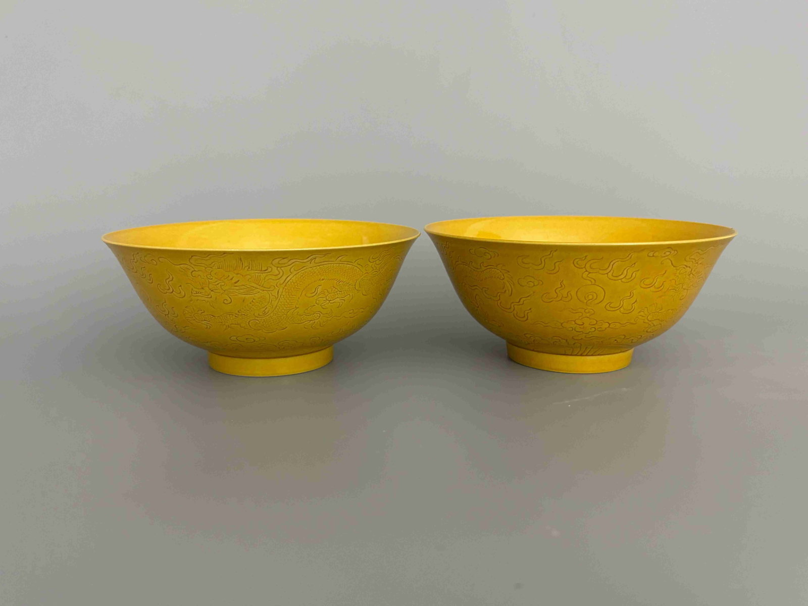 Qing Guangxu Yellow-Glazed "Twin Dragons Playing" Bowls (Pair): Qing Guangxu Yellow-Glazed "Twin Dragons Playing with Pearl" Bowls, Pair. Qing Dynasty, Guangxu Period, 1875-1908Height: 6.7cm Mouth Diameter: 15cm Base: 6.2cm Description: A pair of bowls, each risin