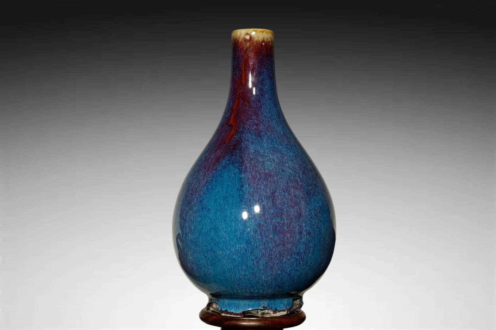 Qing Dynasty FLAMBE-GLAZED PEAR-SHAPED VASE: A FINE FLAMBE-GLAZED PEAR-SHAPED VASE (YUHUCHUN PING) Qing Dynasty, 18th Century Height:13.5cm. Description: Of striking chromatic effect, this pear-shaped vase is covered in a flambé glaze, a conflu