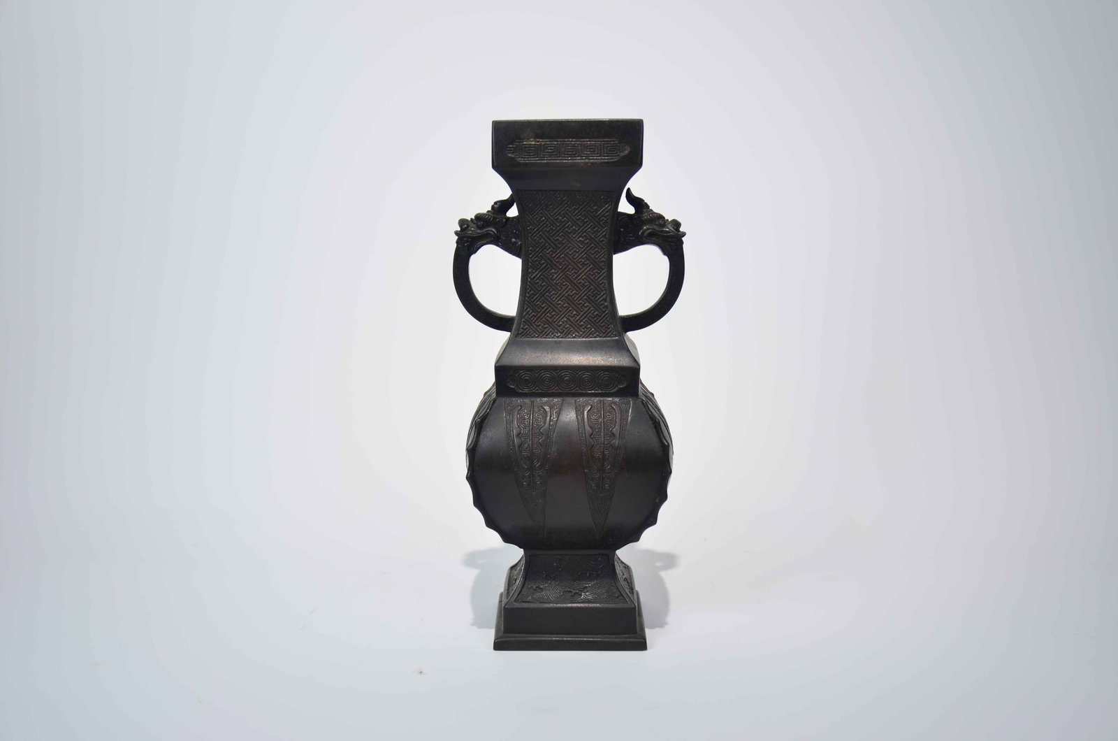 Qing Dynasty Bronze-Body Plantain-Leaf Dragon handle Square Zun Vase: Qing Dynasty Bronze-Body Plantain-Leaf Twin-Dragon-Handle Square Zun Vase. Qing Dynasty, 18th-19th Century Mouth Diameter: 7cm Height: 26cm Base: 7.5cm. Description: A bronze vase of square-sectioned 