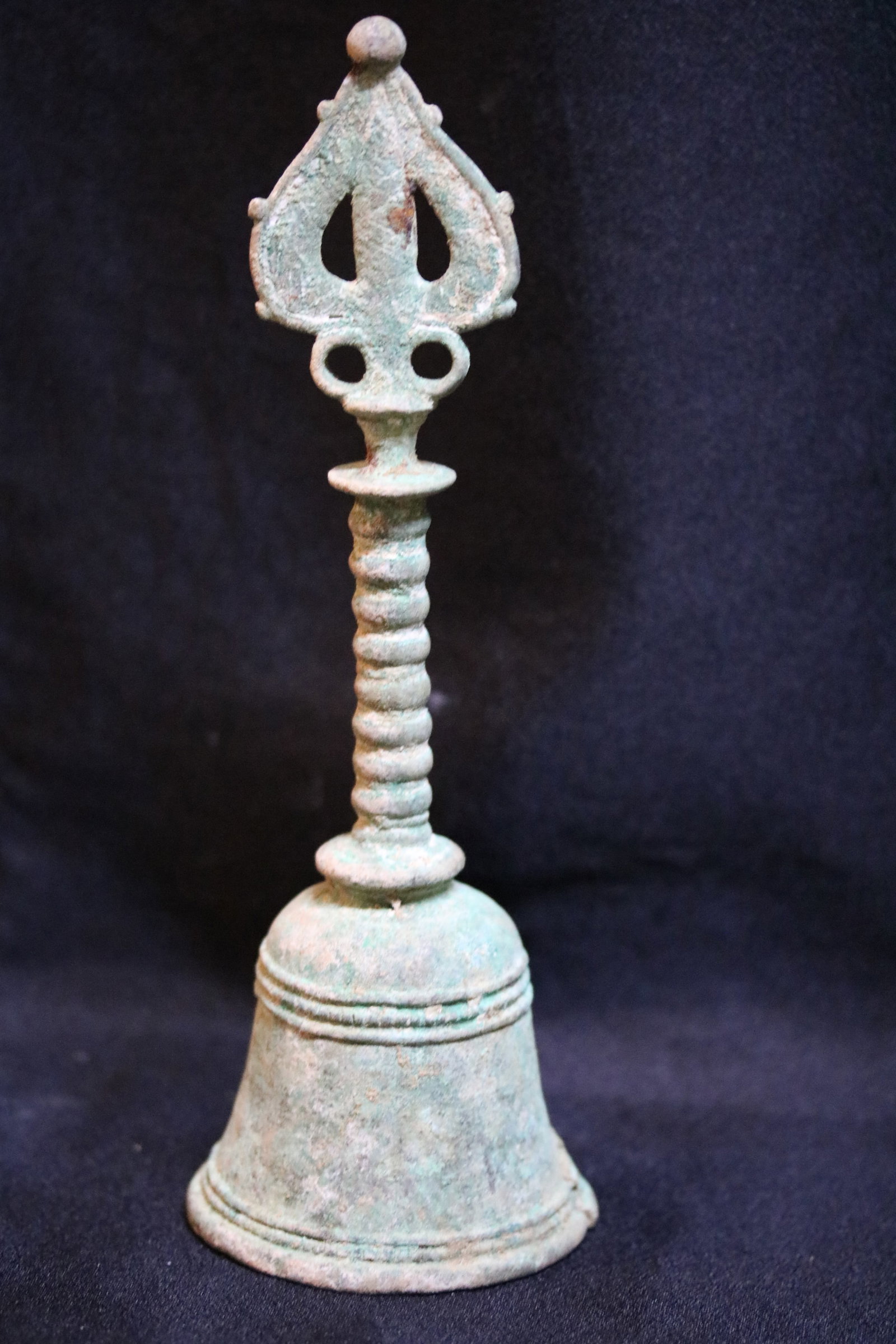 Gandhara Bronze Ritual Handbell: Gandhara Bronze Ritual HandbellGandhara Region, Kushan Period, 1st-2nd Century ADHeight: 25.5cmDescription: Cast in bronze with a rich green burial patina, this ritual handbell has a flared, bell-shap