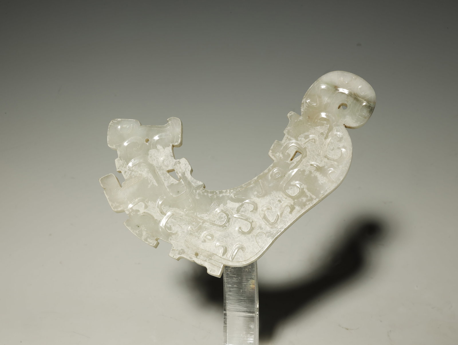 Zhou Dynasty Pale Celadon Jade 'Dragon' Pendant: A RARE AND FINELY CARVED PALE CELADON JADE 'DRAGON' PENDANT. Eastern Zhou Dynasty, Warring States Period, circa 4th–3rd Century B. Diameter 16.5 cm. Description: This elegantly curved pendant (pei) 