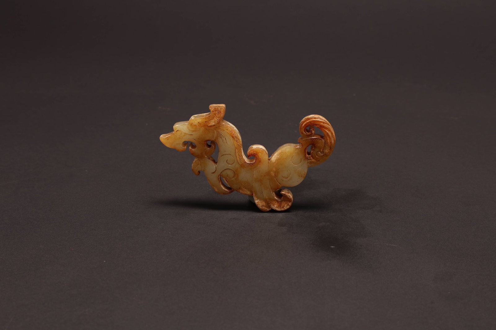 Han Dynasty Chilong Jade Pendant: Han Dynasty Chilong Jade PendantHan DynastyLength: 8cm Width: 5cm Depth: 0.7cmDescription: An openwork jade pendant carved as a sinuous chilong (???), the horned, maned head turned back over an S-curv