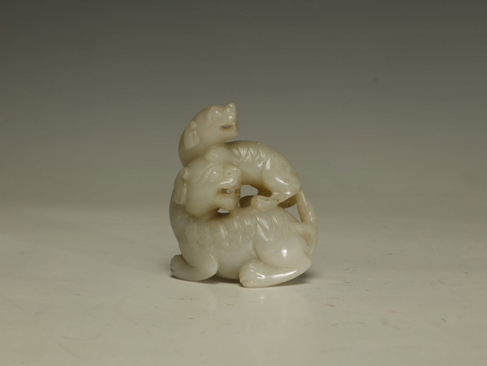 Qing Dynasty HETIAN WHITE JADE MOTHER AND CHILD DOUBLE BEAST HAND PIECE: A NOTABLE QING DYNASTY HETIAN WHITE JADE MOTHER AND CHILD DOUBLE BEAST HANDPIECE. Chinese, 18th–Chinese 19th Century. Height 7 cm × Length 6 cm × Width 2 cm. Description: Superbly carved from tran