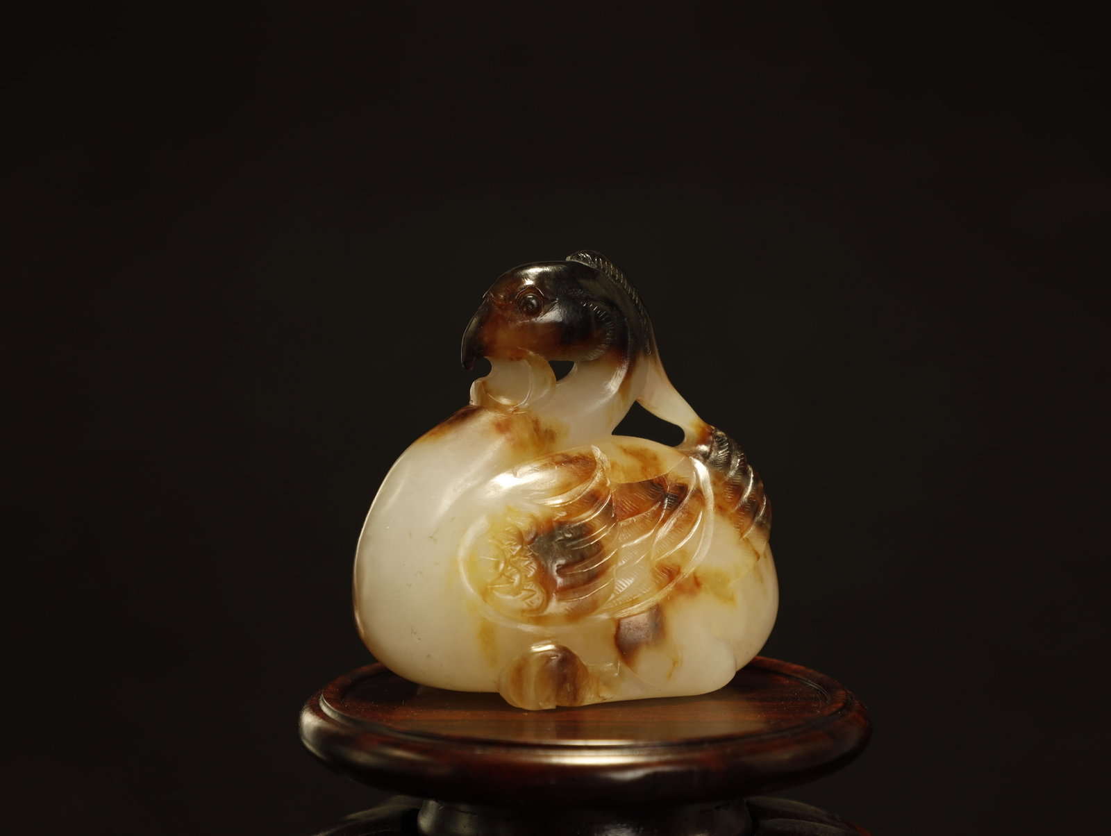 Tang Dynasty White and Russet Jade Carving of a: A Fine White and Russet Jade Carving of a Xuanniao (Mystic Bird)Chinese, Tang DynastyHeight 4.6 cm × Length 4.8 cm × Width 3 cmDescription: A small jade carving of a stylized bird, worked in a pale 