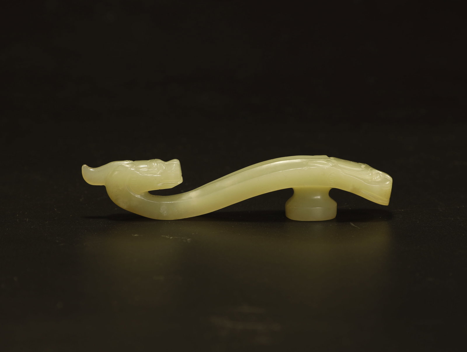 Han Dynasty Jade Belt Hook: An Exceptional Han Dynasty Jade Belt HookChinese, Han Dynasty (206?BCE?–?220?CE)Length 9.5 cm × Width 1.5 cmDescription: Elegantly carved from pale celadon jade, this belt hook features a sinous dr