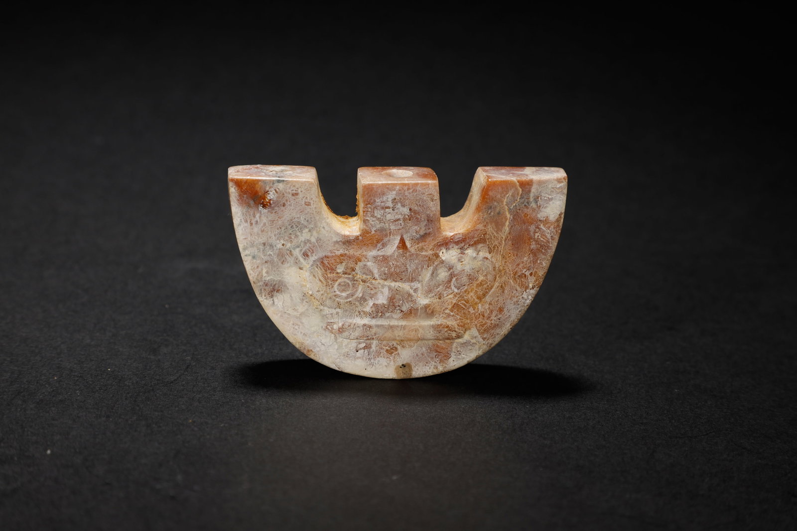 Han Dynasty Notable Archaic Russet Jade Notched: A Notable Archaic Russet Jade Notched Plaque with Eye-and-Scroll MotifChinese, Han DynastyLength 3.6 cm × Width 6 cmDescription: A jade carving of flattened, fan-shaped form, the arced upper edge not