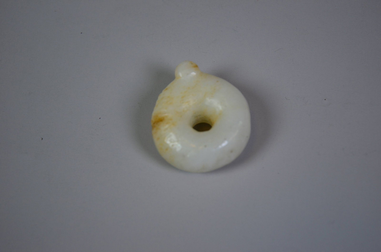 Neolithic Hongshan Culture Hetian Jade Pig-Dragon: Neolithic Hongshan Culture Hetian Jade Pig-DragonNeolithic Hongshan CultureDiameter: 3.5cm Weight: 49.8gDescription: A C-shaped ring pendant carved as a coiled pig-dragon (zhulong), the body forming a