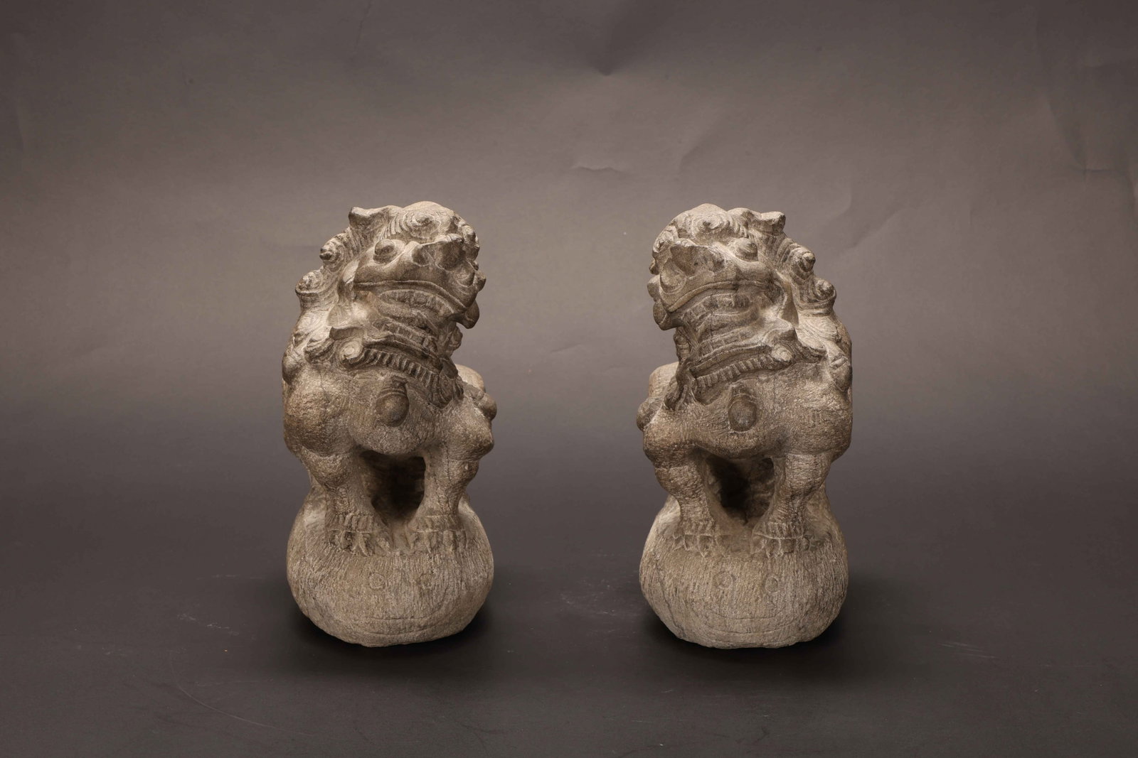 Qing Dynasty Bluestone Lion Figures, Pair: Qing Dynasty Bluestone Lion Figures, PairQing DynastyHeight: 19.5cm Base Length: 10cm Width: 9.5cmDescription: A pair of small seated lion figures, each carved from a grey bluestone, the mane rendered