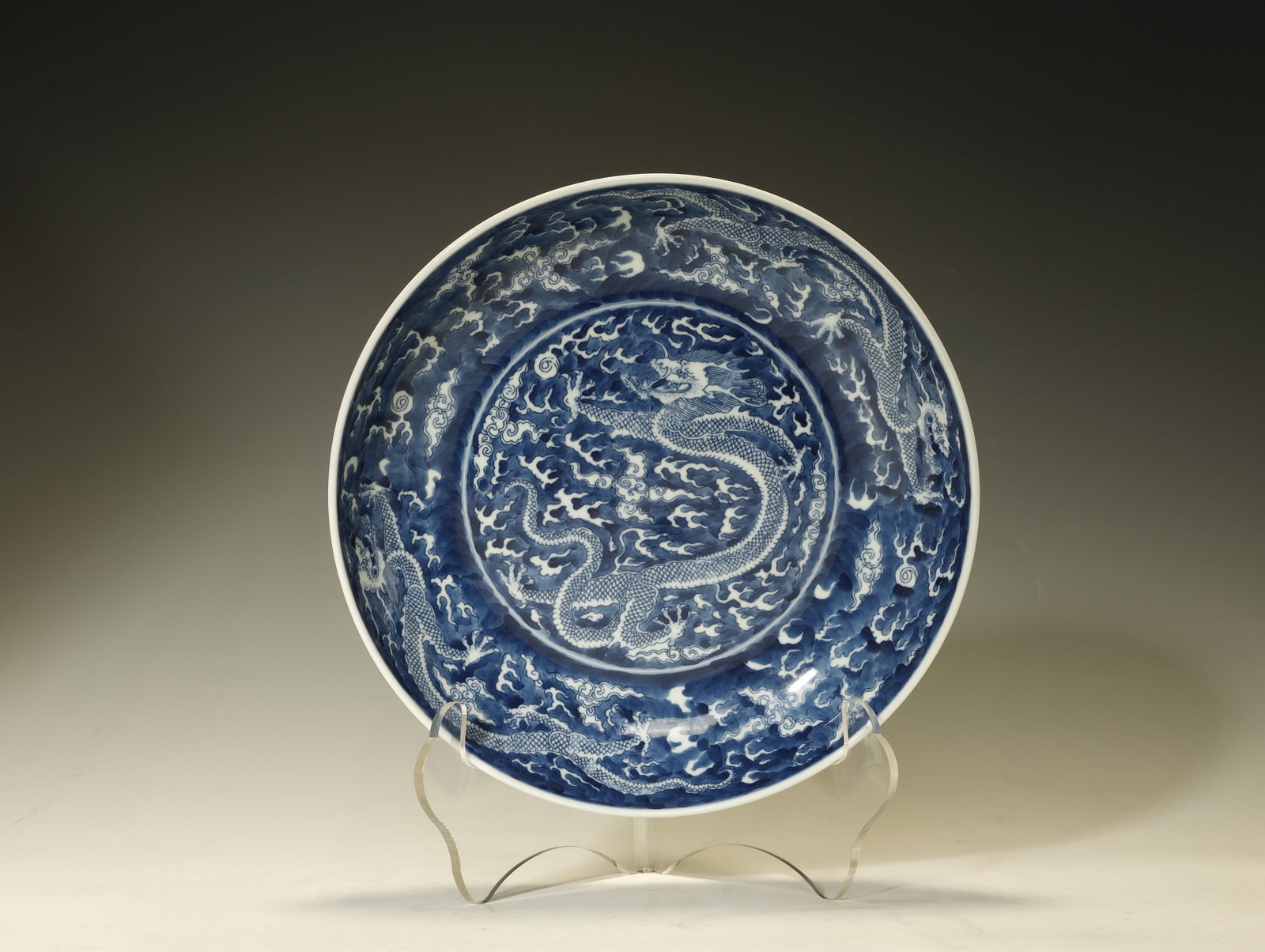 Qing Dynasty - A Blue-and-White 'Dragon' Charger: A Blue-and-White 'Dragon' ChargerChina, Qing DynastyHeight: 2 in. (5 cm); diameter 9.8 in. (25 cm)Description: A blue-and-white porcelain charger, the interior painted with a central medallion enclosi