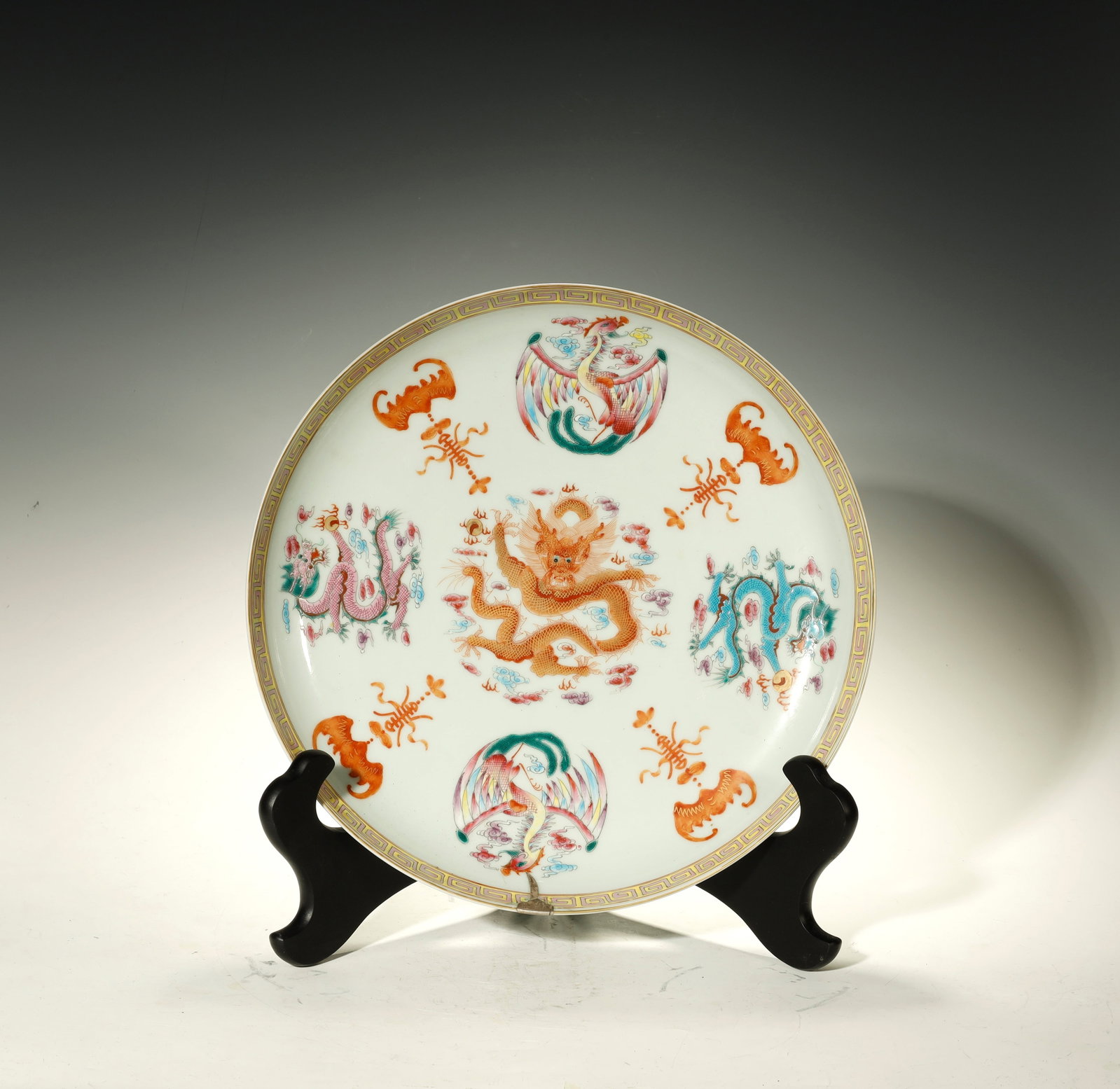 Qing Dynasty Famille Rose 'Dragon, Phoenix and Bat' Charger: A Famille Rose 'Dragon, Phoenix and Bat' ChargerChina, Qing DynastyHeight: 2.6 in. (6.5 cm); diameter 14.2 in. (36 cm)Description: A large famille rose porcelain charger, the white ground painted at t
