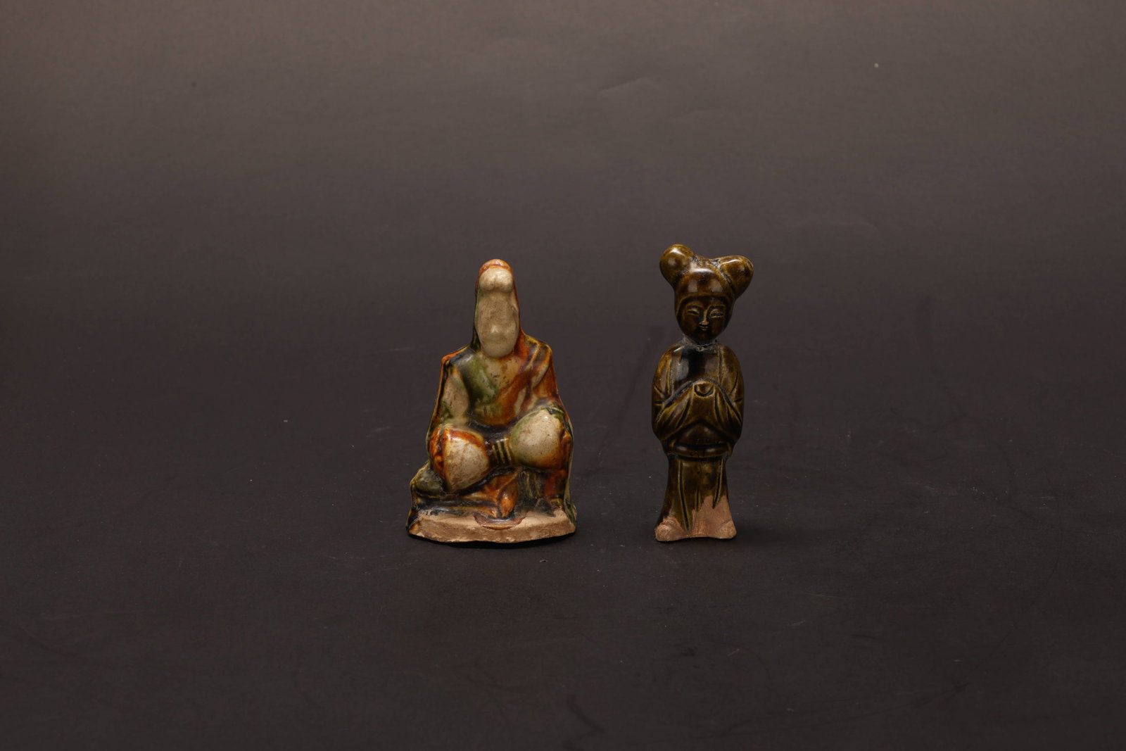 Tang Dynasty Court Attendant Figurines, Set: Tang Dynasty Court Attendant Figurines, SetTang DynastyDancer: Height: 8cm Base / Foot: 4.8cmDescription: Two small figures: one seated cross-legged with hands folded at the waist, wrapped in a mantle