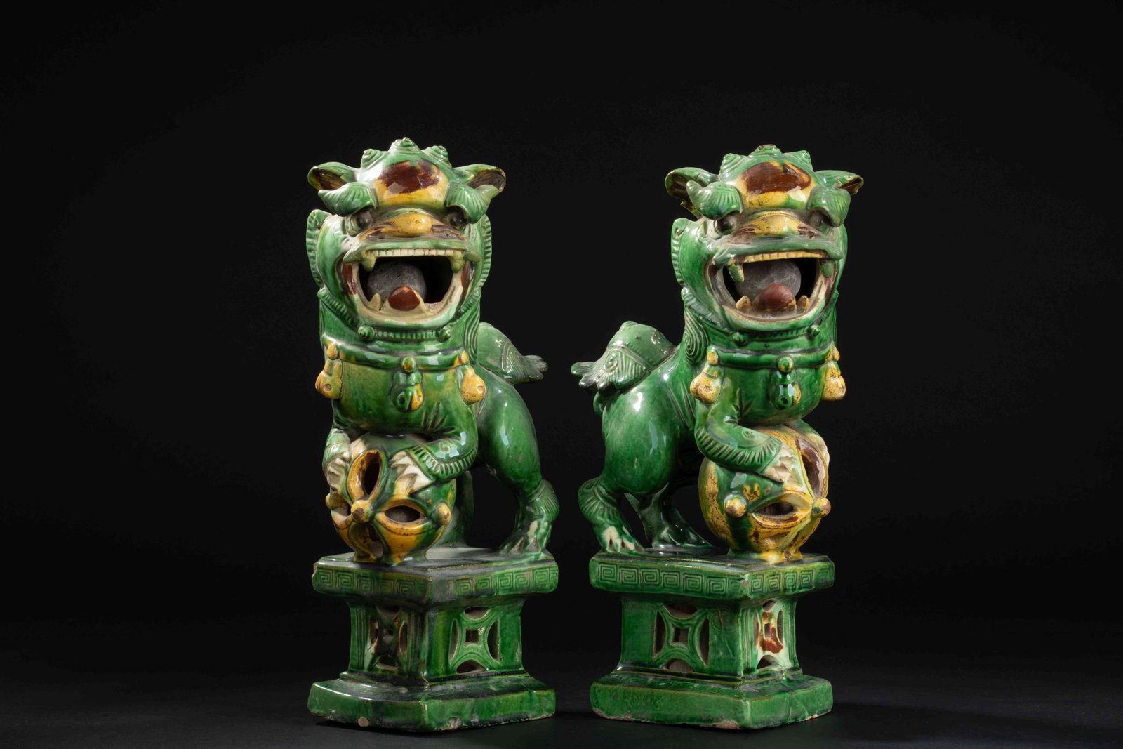 Ming Dynasty Plain Sancai-Glazed Lion Ornaments: Ming Dynasty Plain Sancai-Glazed Lion Ornaments, PairMing DynastyH: 13 in. (33cm)Description: A pair of pottery figures each modeled as a seated lion, the head turned slightly to one side with an open