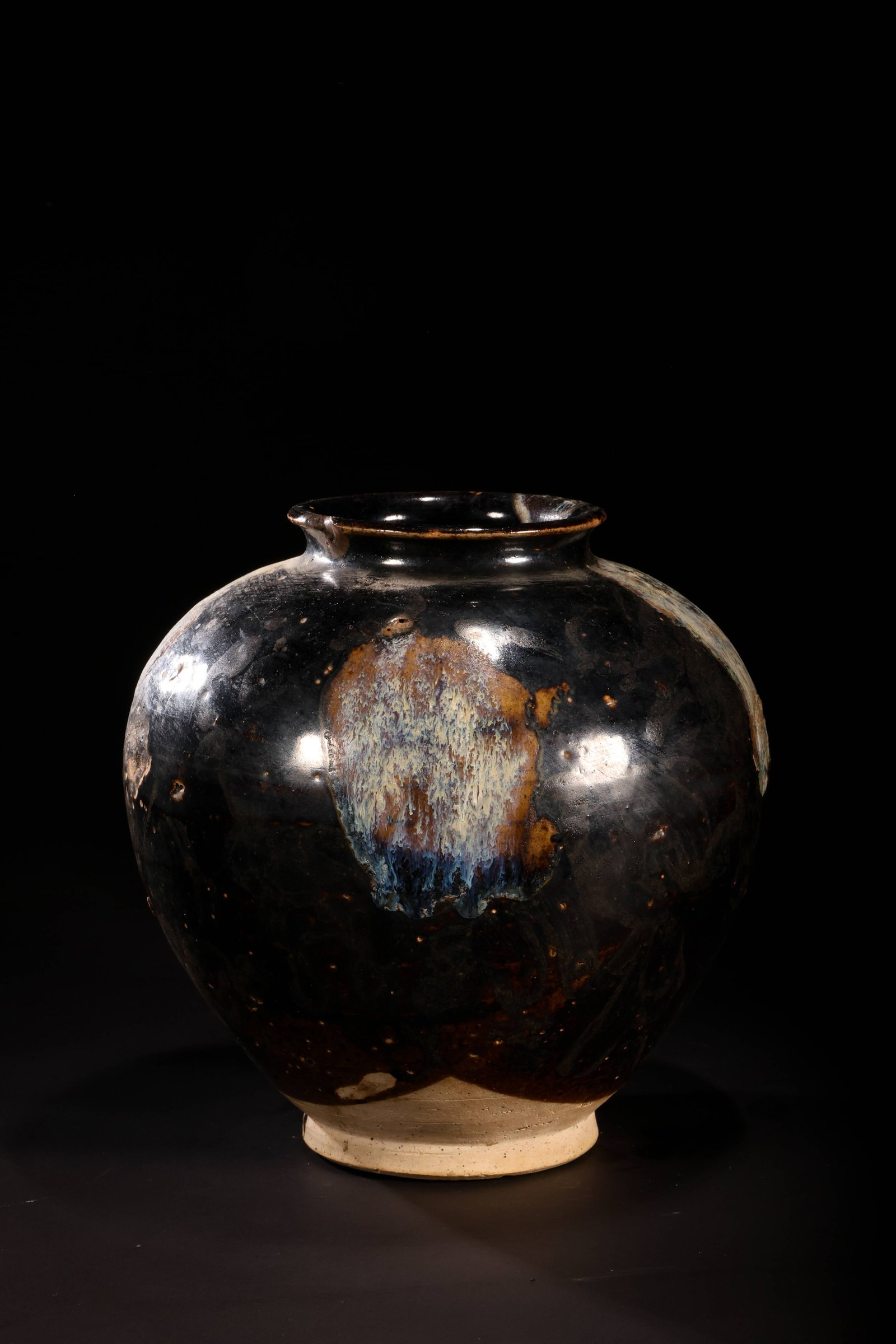 Lushan Ware Black-Glazed Jar: Lushan Ware Black-Glazed JarTang Dynasty (618-907 AD)Height: 19cm Base / Foot: 9cmDescription: A globular stoneware jar with a short, flared neck, covered overall in a glossy black glaze splashed with