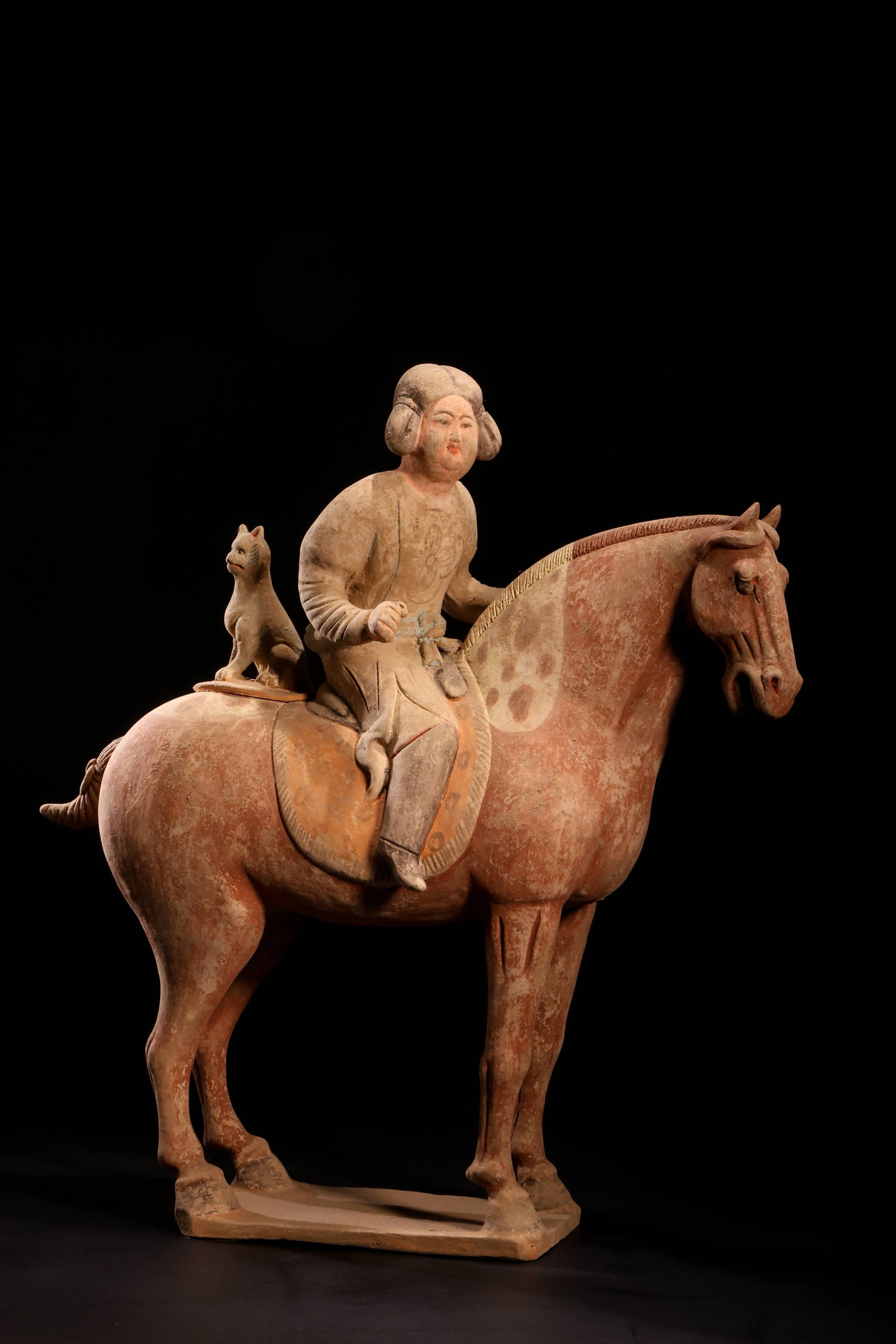 Tang Dynasty Court Lady with Hunting Dog on: Tang Dynasty Court Lady with Hunting Dog on Horseback FigurineTang Dynasty (618-907 AD)Height: 35cm Length: 33cmDescription: A pottery figure of a court lady seated astride a standing horse, her hair 