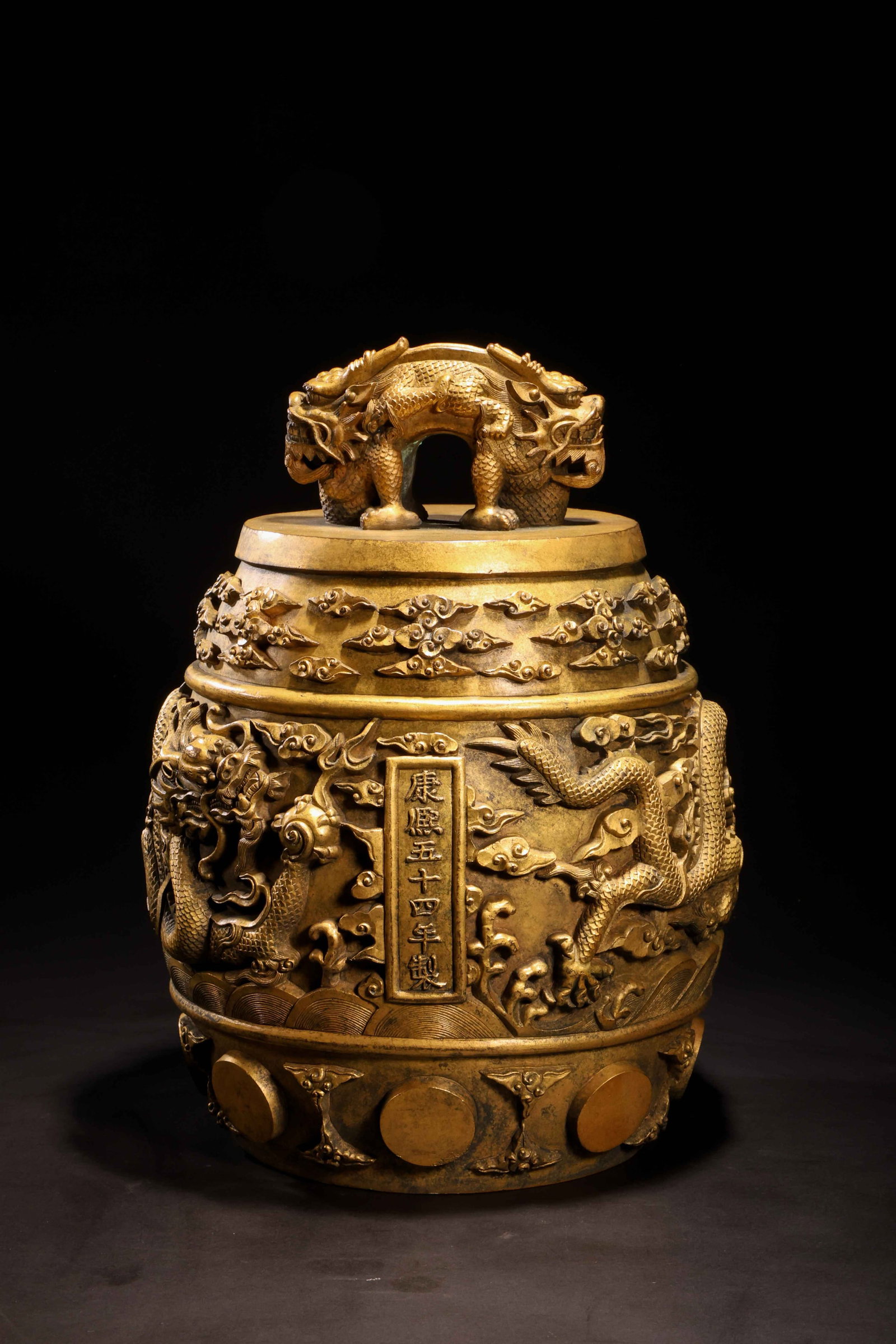 Qing Kangxi Gilt-Bronze Dragon-Head Bell: Qing Kangxi Gilt-Bronze Dragon-Head BellQing Dynasty, Kangxi PeriodHeight: 29cm Mouth Diameter: 15cmDescription: A barrel-form gilt-bronze bell, the body cast in relief with two confronting five-clawe