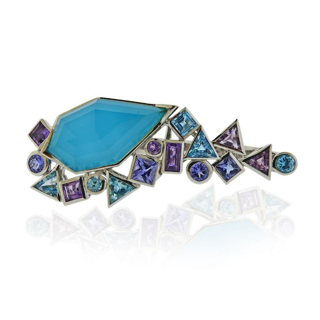 Stephen Webster Gold Struck Turquoise Tanzanite Two: Metal : 18k White Gold Designer : Stephen Webster Gemstone : Turquoise, Amethyst, Quartz, Tanzanite, Topaz Measurements : Ring sizes - 6 and 7, top is 20mm x 50mm Marked: : 750, SW, English