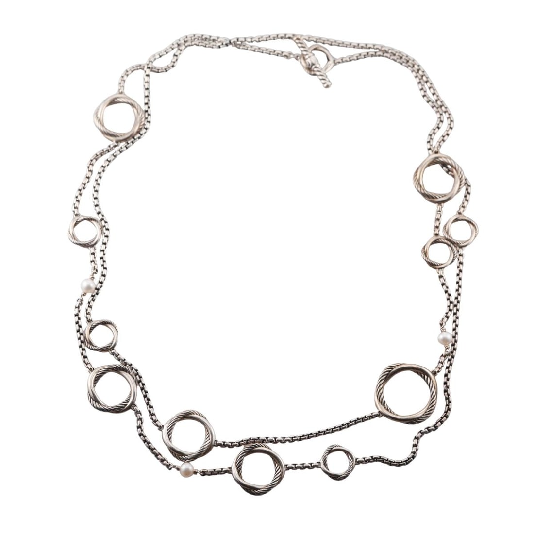 David Yurman Infinity Sterling Silver Pearl Long Toggle Necklace: Metal : Sterling Silver Designer : David Yurman Gemstone : Pearls 5.5mm Measurements : Necklace is 44" long Marked: : D.Y., 925 Weight: : 63.3 grams Condition: : Very Good Additional: n/a