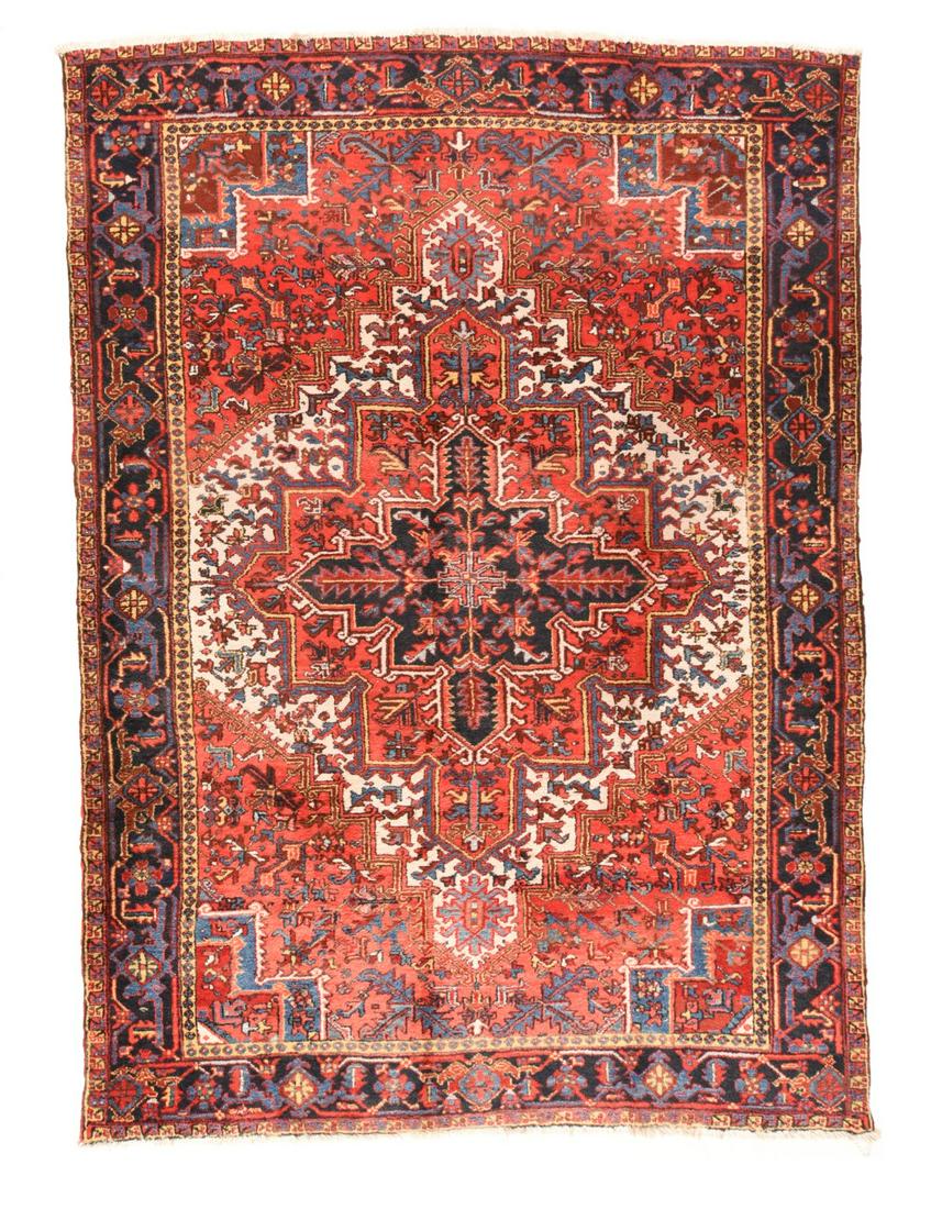 Heriz Rug, 7'9'' x 10'11'': A tonal inversion, with large, rust red, stepped corners, and a somewhat restricted ecru field anchored by a large rust red and navy nested leaf medallion. Stepped light blue corner cores. Straw inner