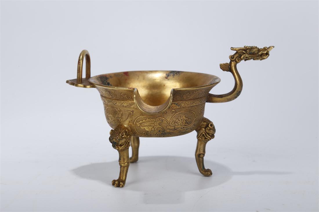 A GILT COPPER TRIPOD GOBLET. (1 of 9)