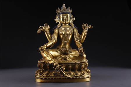 A GILT BRONZE VASUDHARA BUDDHA STATUE.