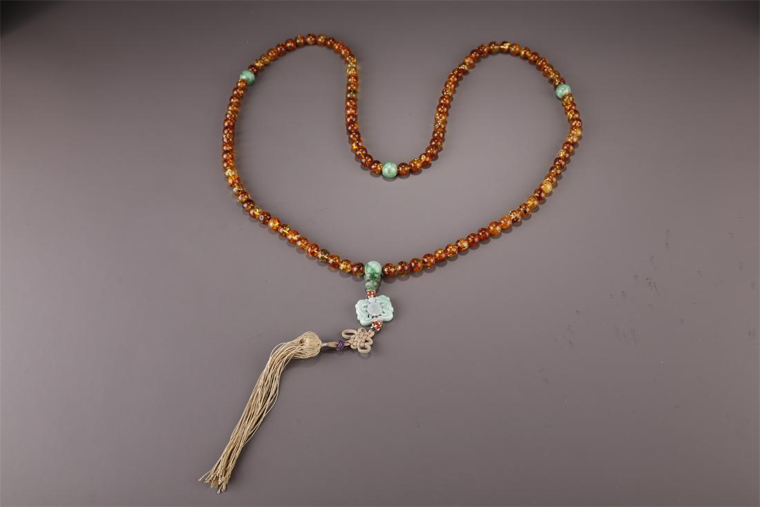 A STRING OF AMBER BUDDHA BEADS. (1 of 6)