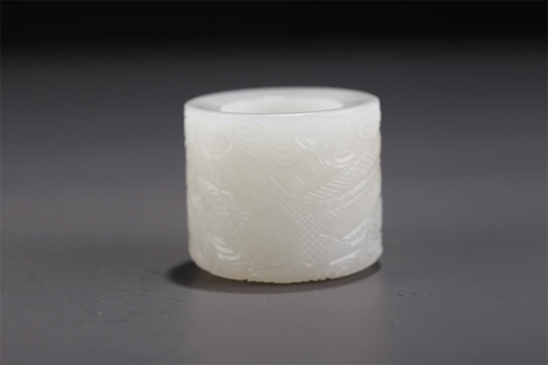 A HETIAN JADE THUMB RING WITH DRAGON DESIGN. (1 of 6)