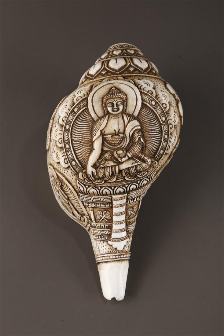 A CONCH IMPLEMENT WITH CARVED SAKYAMUNI DESIGN. (1 of 9)