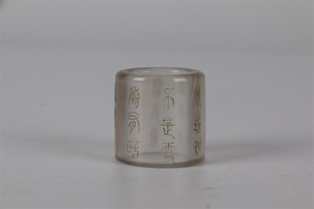 A GLASS THUMB RING WITH CARVED POEM DESIGN. (1 of 6)