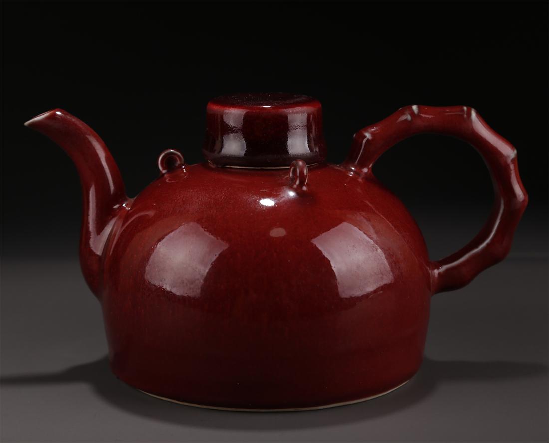 A SHINY RED GLAZED PORCELAIN POT WITH HANDLE. (1 of 9)