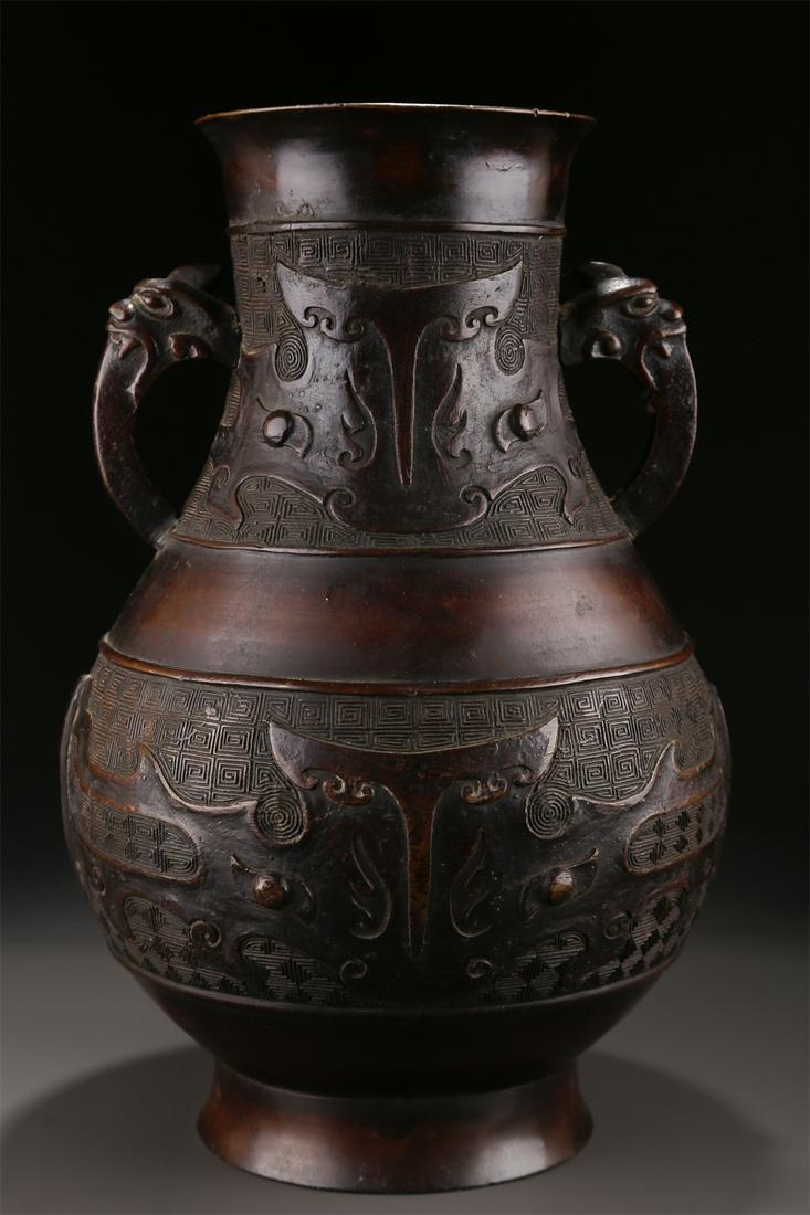 A BRONZE BOTTLE WITH BEAST FACE DESIGN. (1 of 9)