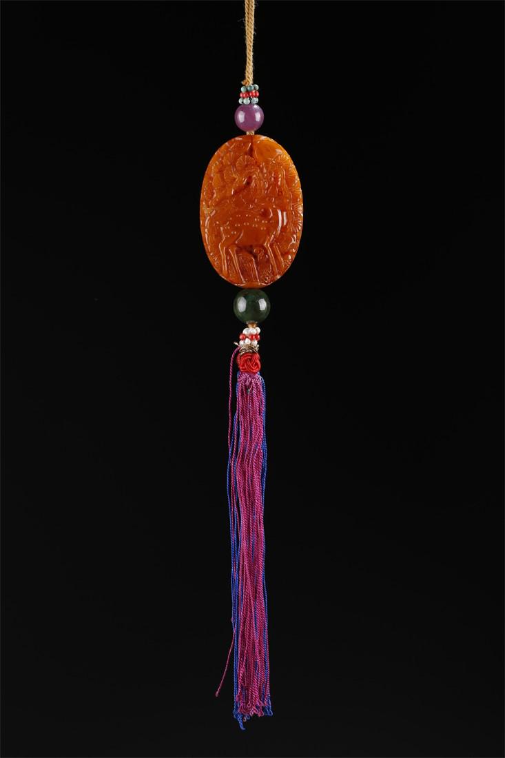 AN AMBER DEER AND CRANE CARVING PENDANT. (1 of 6)