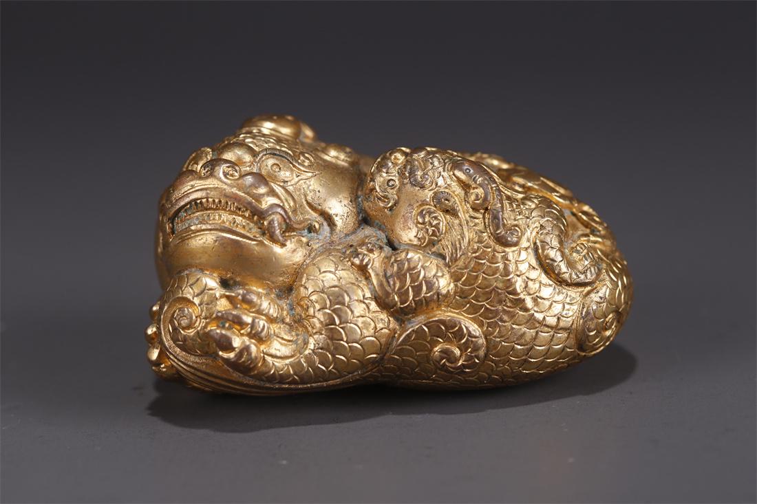 A GILT BRONZE AUSPICIOUS BEAST STATUE. (1 of 8)