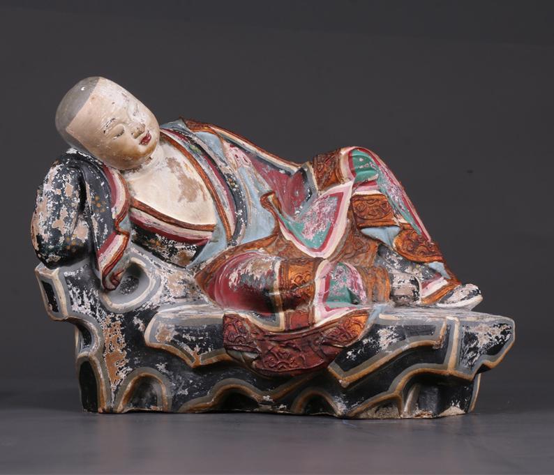 A CLAY SIDE-LYING ARHAT STATUE. (1 of 8)