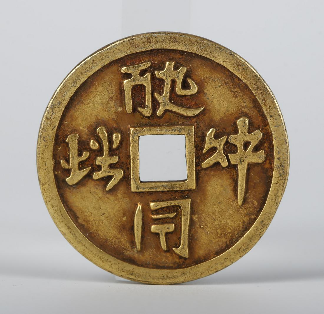 A GILT BRONZE COIN. (1 of 5)