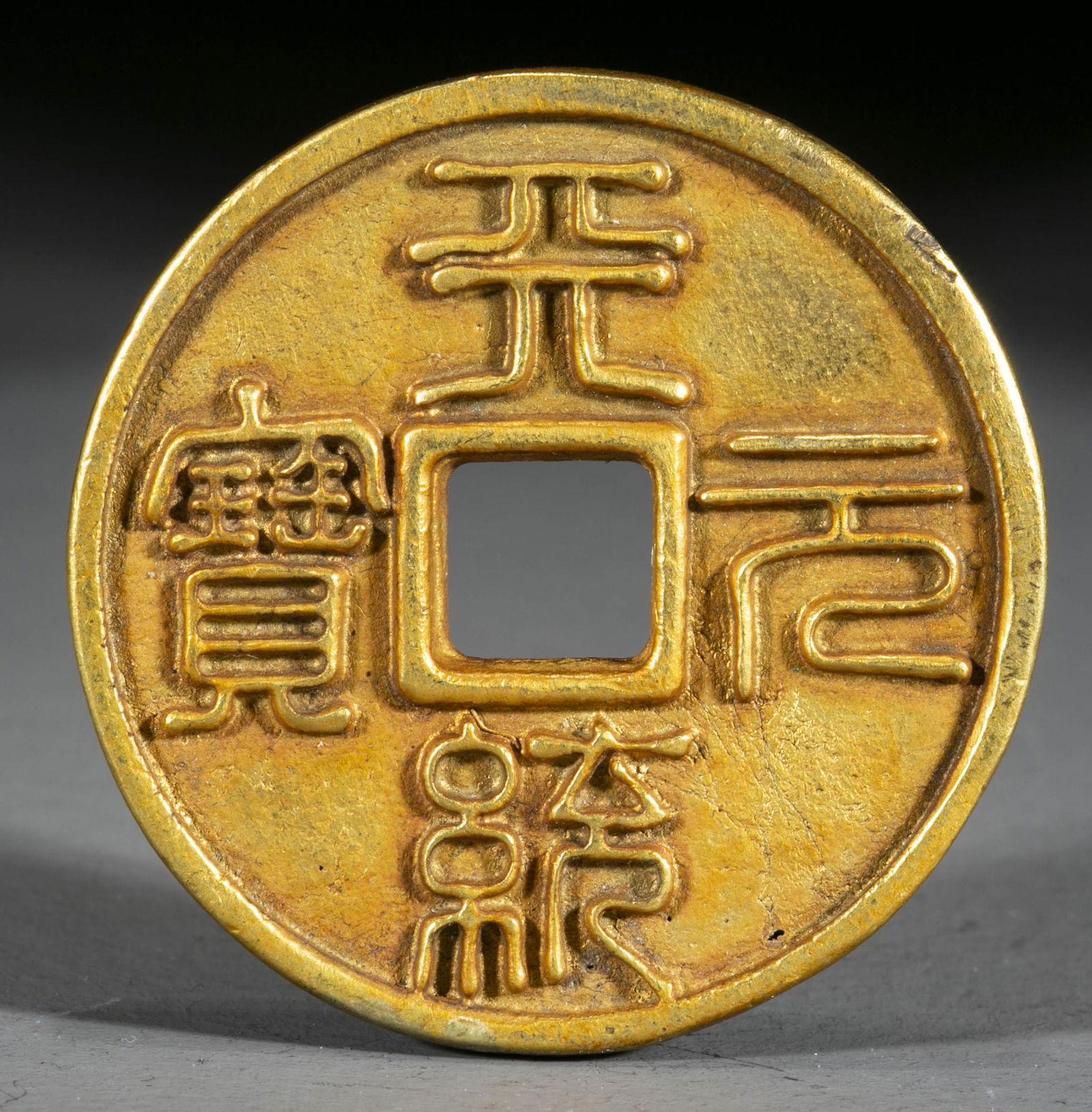 A GILT BRONZE COIN. (1 of 4)