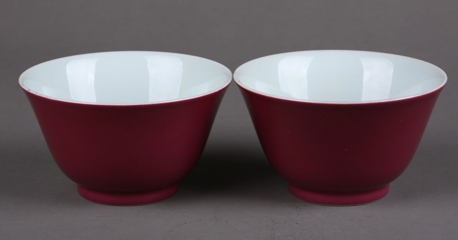 A SET OF CARMINE GLAZED PORCELAIN CUPS.: A Set of Carmine Glazed Porcelain Cups.