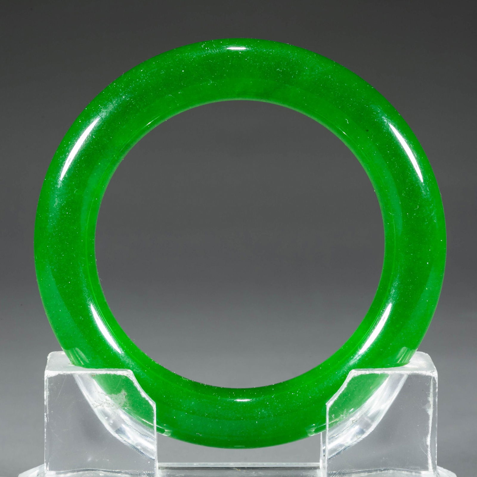 A PURE GREEN JADEITE BANGLE. (1 of 5)