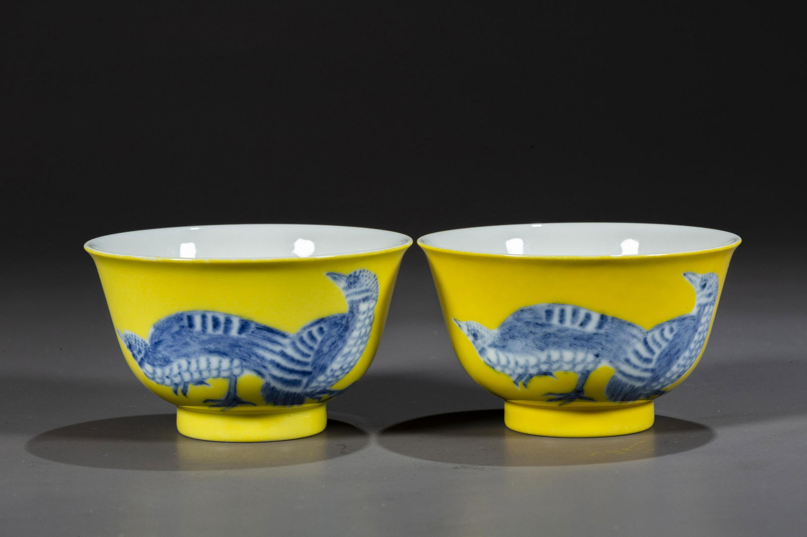 A PAIR OF PORCELAIN CUPS, WITH QUAILS DESIGN.: A Pair of Yellow Porcelain Cups, with Blue-and-White Quails Design, Symbolize Happiness and Peace.